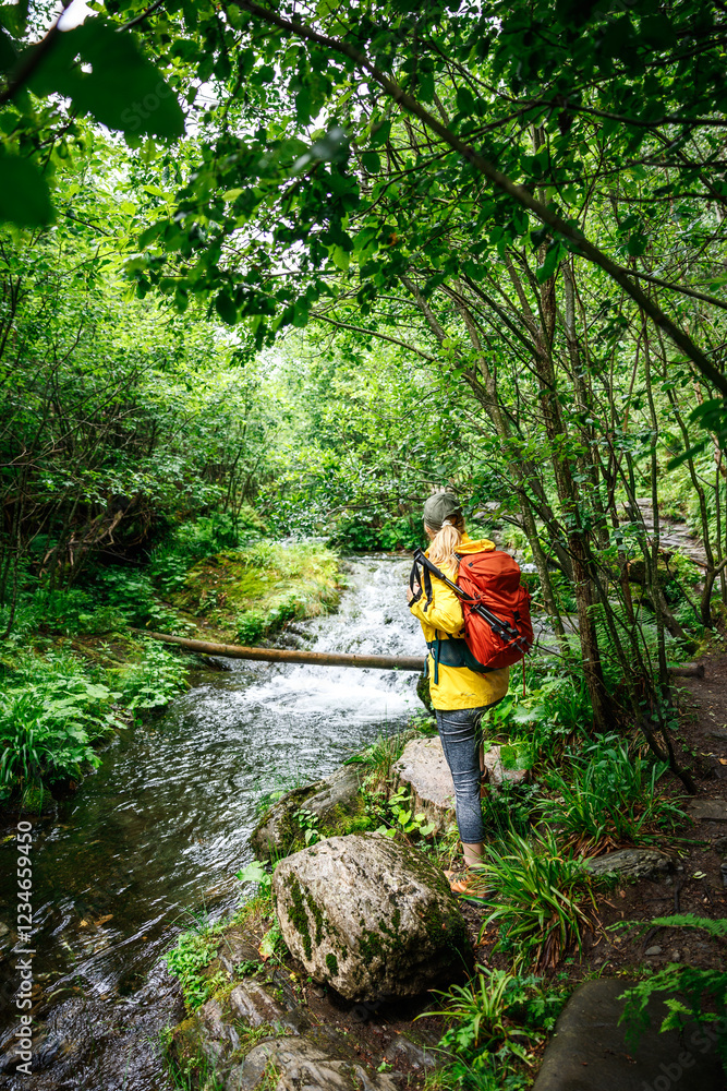 Woman hiker relax at stream in woodland. Forest bathing while hiking in nature. Outdoors activity for mindfulness and mental wellbeing Woman hiker relax at stream in woodland. Forest bathing while hiking in nature. Outdoors activity for mindfulness and mental wellbeing