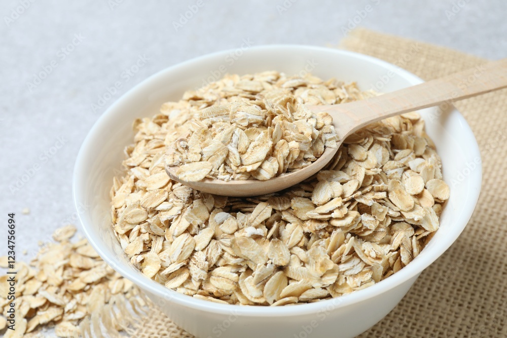 Composition with oatmeal flakes on gray background. Cooking breakfast Composition with oatmeal flakes on gray background. Cooking breakfast