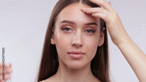 Wallpaper Mural Portrait of an attractive girl with healthy clear skin and beautiful makeup, she applies moisturizing serum. The girl shows her well-groomed skin on her face and neck. Torontodigital.ca