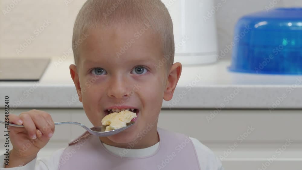 Hyperactive excited child at dinner table. Cheerful little boy smiling, playing around while eating at home Hyperactive excited child at dinner table. Cheerful little boy smiling, playing around while eating at home