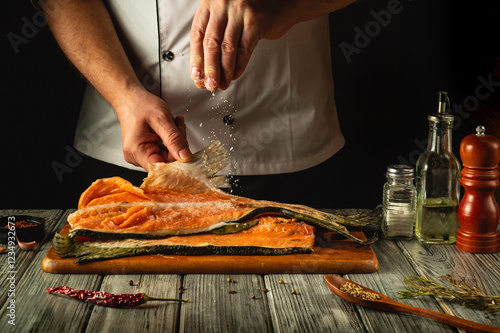 Картината върху платно Skilled hands carefully sprinkle salt over vibrant salmon fillets laid on a rustic wooden board, preparing for a culinary delight