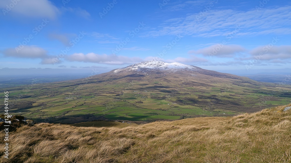 Snow capped mountain overlooking a vast green valley Snow capped mountain overlooking a vast green valley