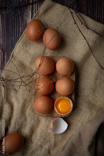 Brown chicken eggs in wooden base on dark background, perfect for easter, natural light   photo