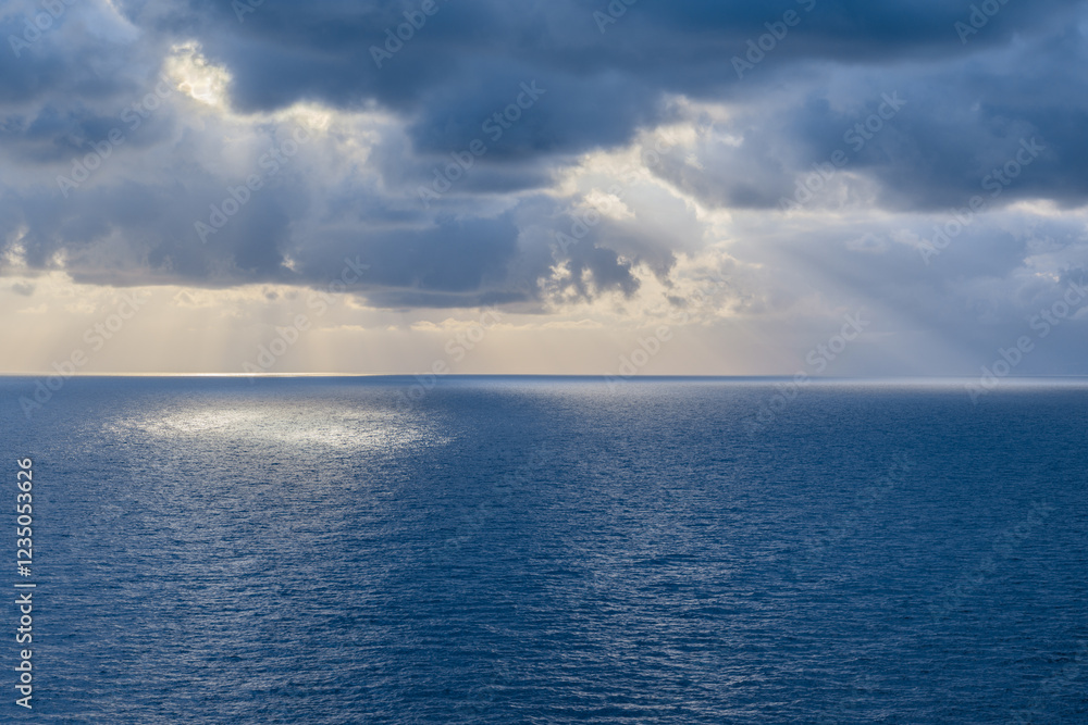 Sunbeams through the clouds illuminating the sea. Sunbeams through the clouds illuminating the sea.