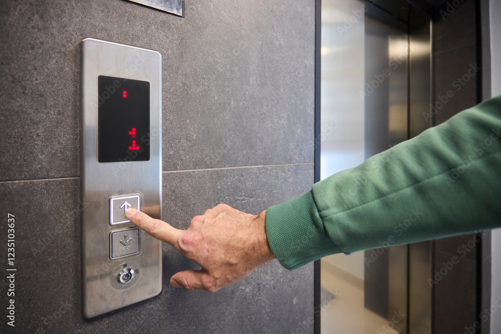 Pressing the elevator button in contemporary high rise buildings signifies modern urban convenience Pressing the elevator button in contemporary high rise buildings signifies modern urban convenience