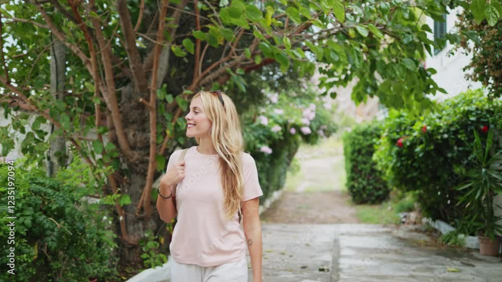 Tourist woman walking in a green alley Tourist woman walking in a green alley