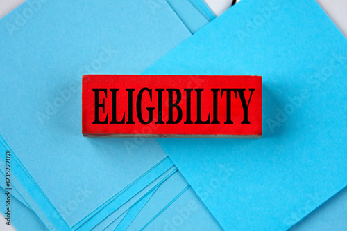 Tableau sur toile ELIGIBILITY - word on a red wooden block on a blue background of papers