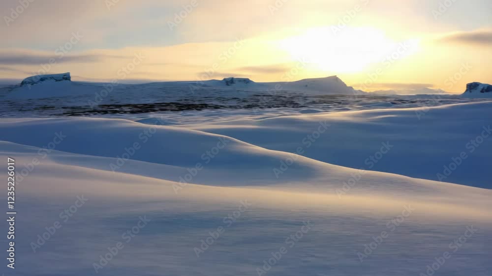 Arctic sunset casts long shadows across a vast snow-covered landscape Arctic sunset casts long shadows across a vast snow-covered landscape