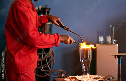 Fotografie Glassblowing, heat and man with blowtorch, shaping and creative for manufacturing of glass and industry