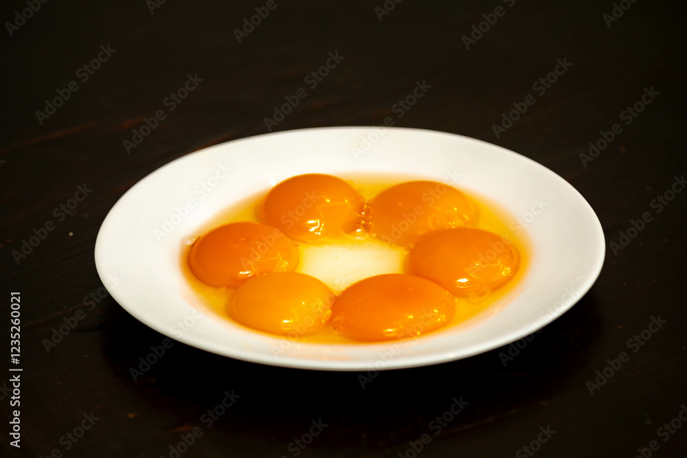egg yolks on white plate isolated on black background egg yolks on white plate isolated on black background