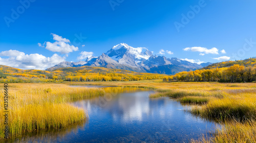 Snow-capped mountain peak reflects in a calm alpine lake surrounded by golden autumn foliage under a clear blue sky.