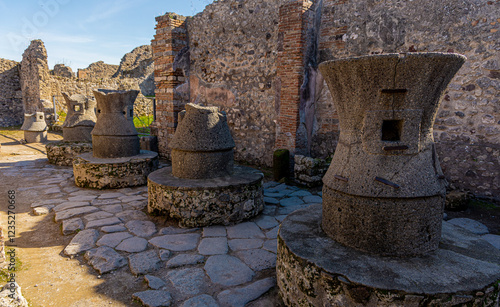 Overview of rotating stone mill for flour at the bakery in pompeii arheological site on a sunny day