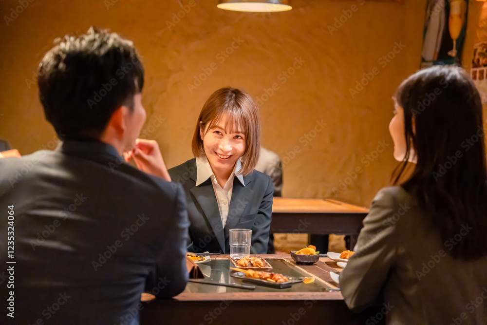 先輩社員と居酒屋で話をするフレッシュな女性 先輩社員と居酒屋で話をするフレッシュな女性