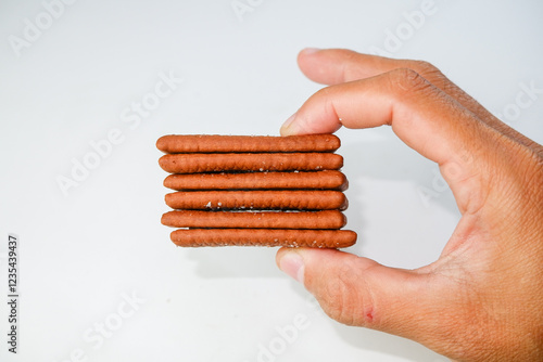 Crispy Chocolate Layered Biscuits Being Held in Hands on a White Background photo