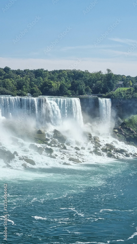 Niagara Falls. A pleasure boat with people near the huge famous waterfall. View from the Canadian side. Nature scenery. Photo for advertising Niagara Falls. A pleasure boat with people near the huge famous waterfall. View from the Canadian side. Nature scenery. Photo for advertising