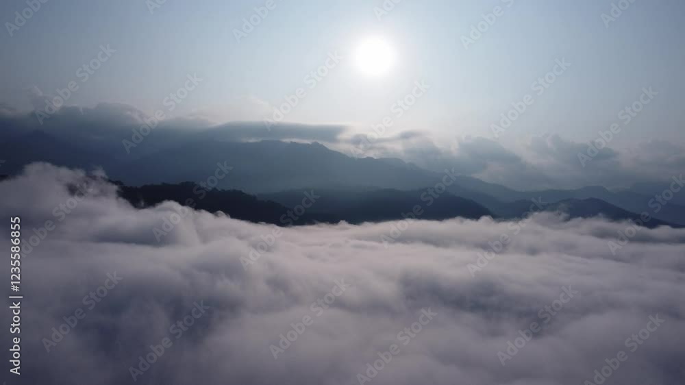 The mountain range with visible silhouettes seen through the colorful fog in the morning. Majestic mountains amidst the sea of mist. The mountain range with visible silhouettes seen through the colorful fog in the morning. Majestic mountains amidst the sea of mist.