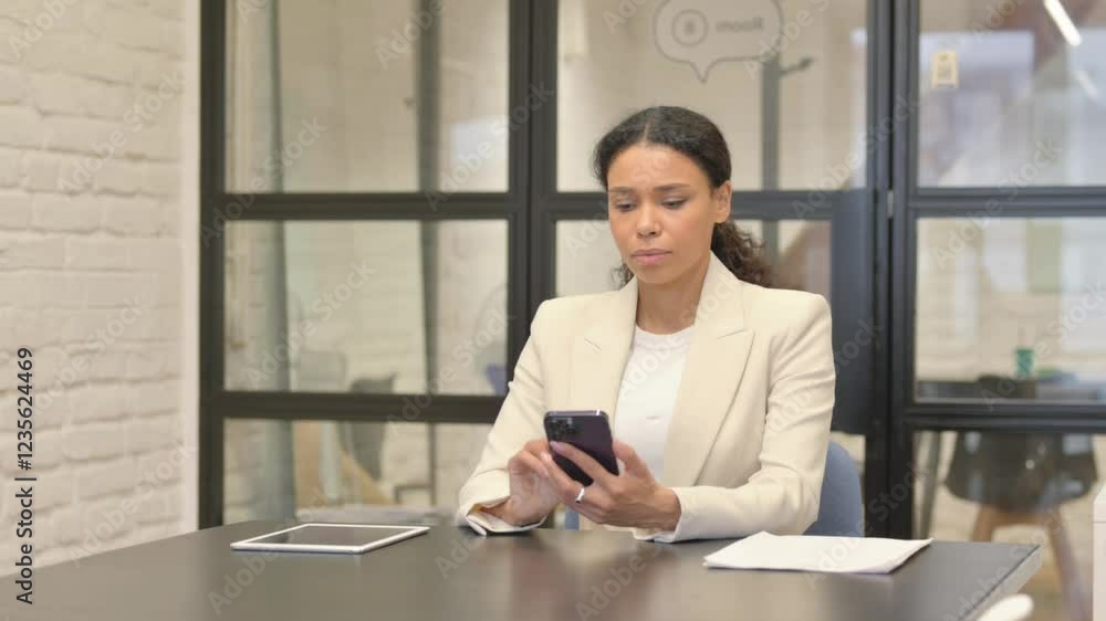 African Business Woman Browsing Internet on Phone in Office African Business Woman Browsing Internet on Phone in Office