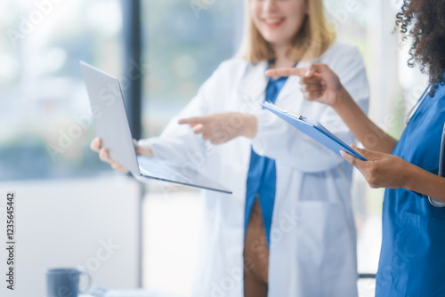 Young African American and Russian woman, both scientists, collaborate to analyze blood samples, viruses, vaccines using microscopes. They conduct crucial medical and biological research. photo