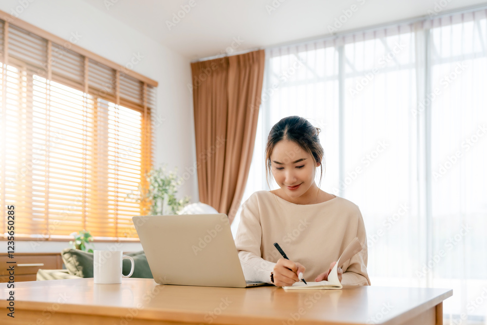 Young Asian woman happy positive cute beautiful business woman sit indoors in living room using laptop computer Young Asian woman happy positive cute beautiful business woman sit indoors in living room using laptop computer