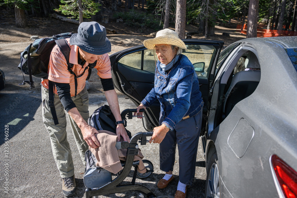 Senior woman getting out of the car and holding a mobility walker with the help of adult son. Family outing with elderly mother. California.