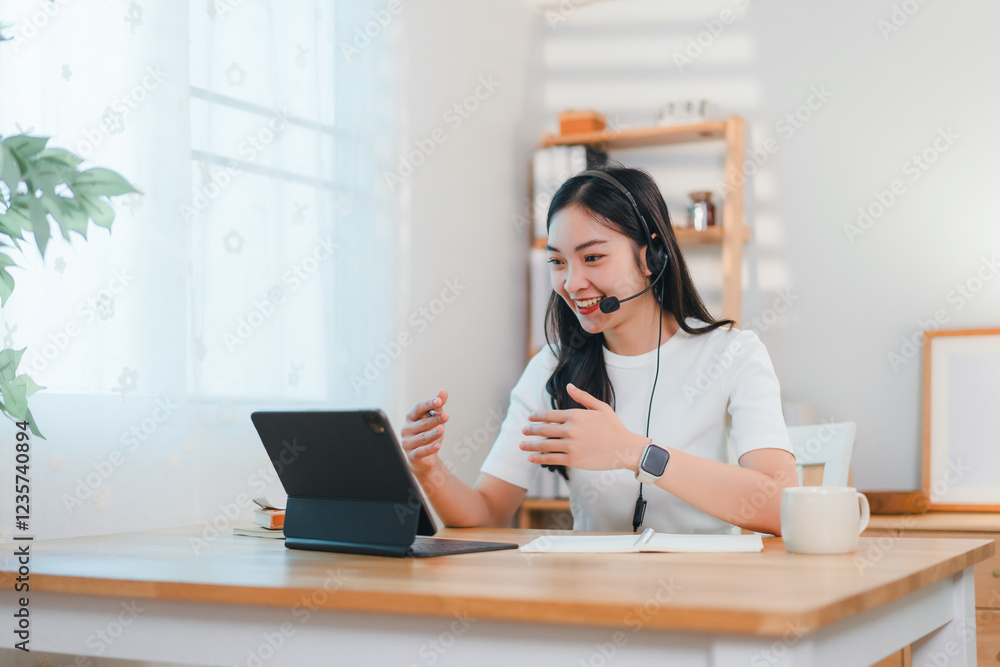 woman wearing headset conducts video call on tablet in bright home office woman wearing headset conducts video call on tablet in bright home office