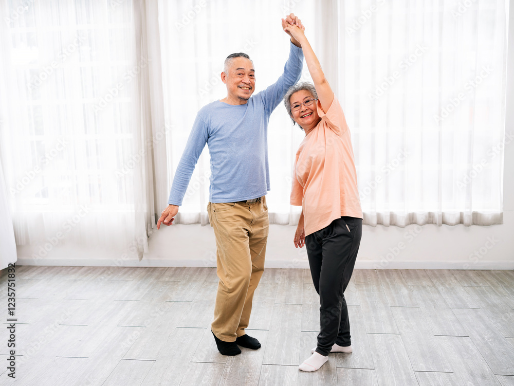 Fototapeta premium Joyful senior couple dances together in bright room, embracing love, companionship, and active aging. They enjoy retirement, active, and aging gracefully. Sharing laughter, wellness, and togetherness.