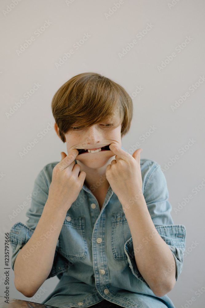 Young boy in chambray shirt making playful faces Young boy in chambray shirt making playful faces