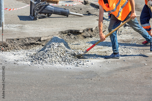 Obraz na płótnie Construction workers engaged in road repair activity on a sunny day. Copy space. w salonie