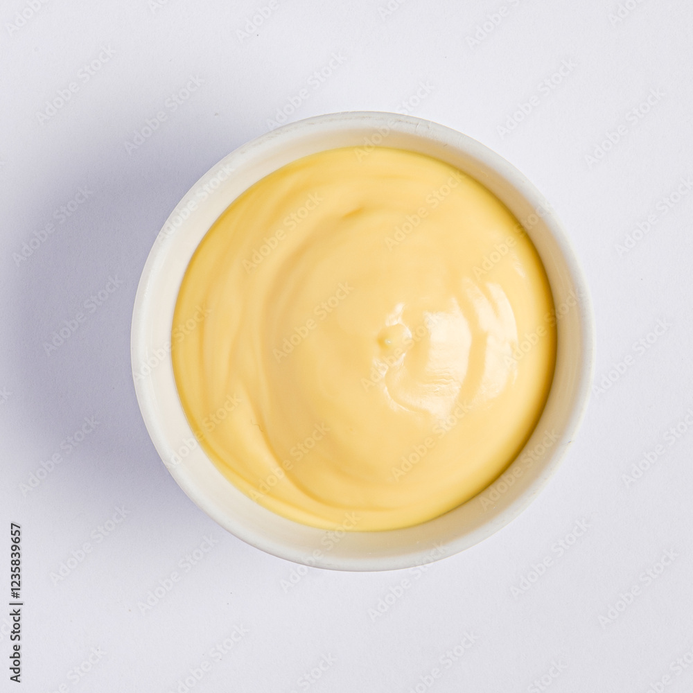 A smooth and luscious creamy yellow sauce fills a simple white bowl, resting on a pristine surface, perfect for enhancing various culinary delights from appetizers to main courses. A smooth and luscious creamy yellow sauce fills a simple white bowl, resting on a pristine surface, perfect for enhancing various culinary delights from appetizers to main courses.