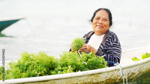 Portrait of smiling seaweed farmer in Nusa lembongan, Bali, Indonesia, on farm or plantation, traditional farming in rural southeast Asia
