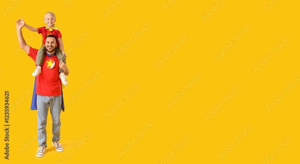 Fototapeta premium Happy father and his little son dressed as superheroes on yellow background with space for text