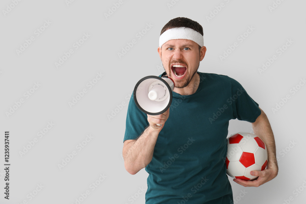 Emotional man with soccer ball and megaphone on light background Emotional man with soccer ball and megaphone on light background