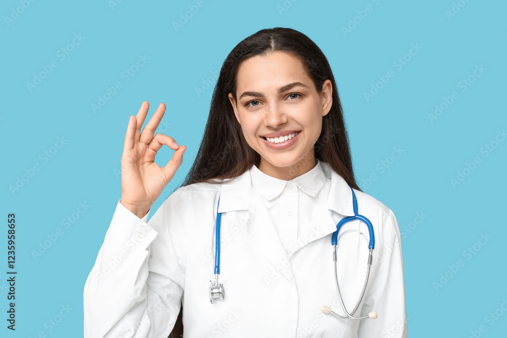 Portrait of female doctor showing OK on blue background Portrait of female doctor showing OK on blue background