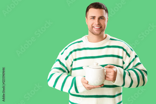Young man with teapot on gr...