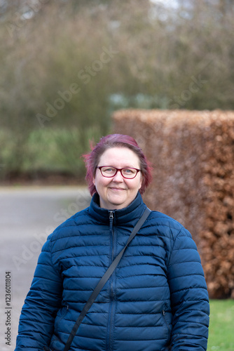 portrait of a middle-aged woman with pink hair and blue jacket photo