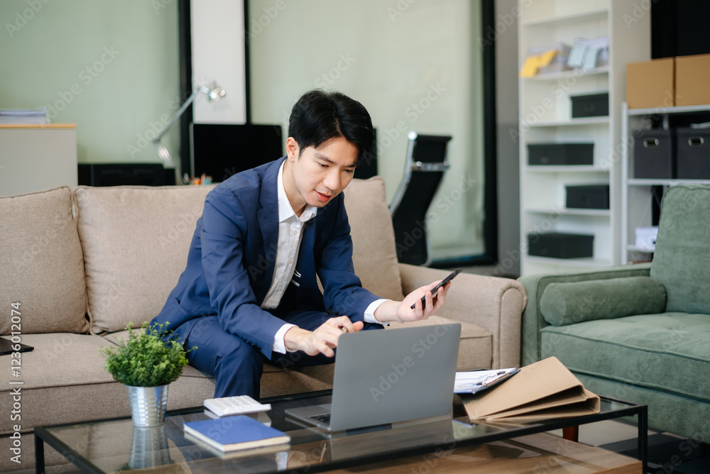 Confident entrepreneur multitasking with a laptop and phone in a modern office. Perfect for business, remote work, finance Confident entrepreneur multitasking with a laptop and phone in a modern office. Perfect for business, remote work, finance