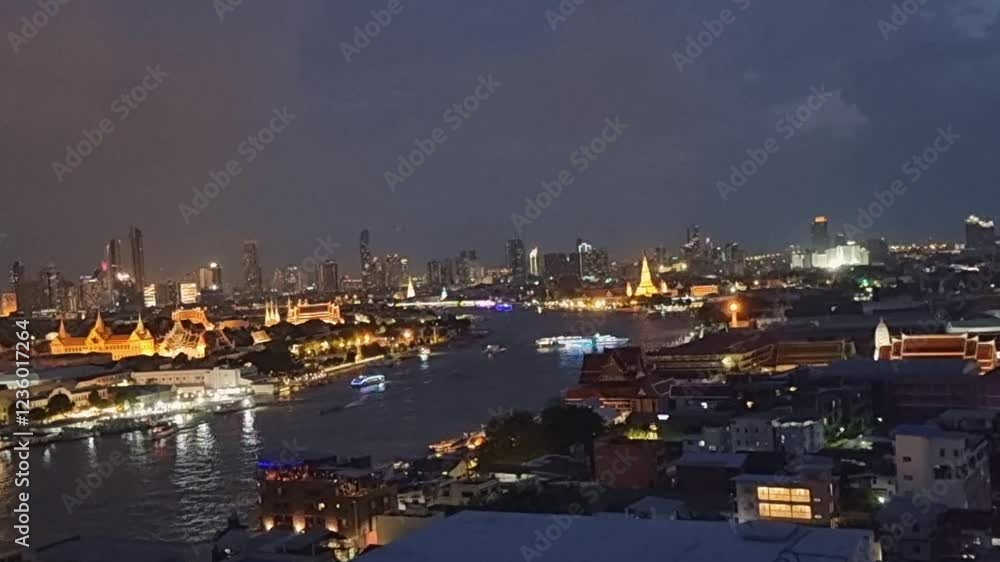 A view of Bangkok taken from a height along the Chao Phraya River with the lights of Wat Arun temple at night and boats navigating the river.mov A view of Bangkok taken from a height along the Chao Phraya River with the lights of Wat Arun temple at night and boats navigating the river.mov
