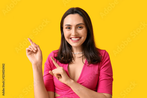 Smiling young woman pointin...