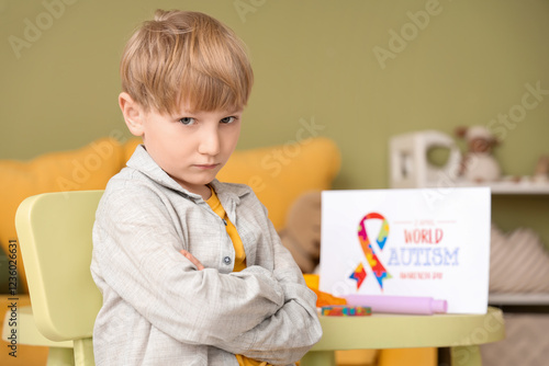 Upset little boy sitting at...