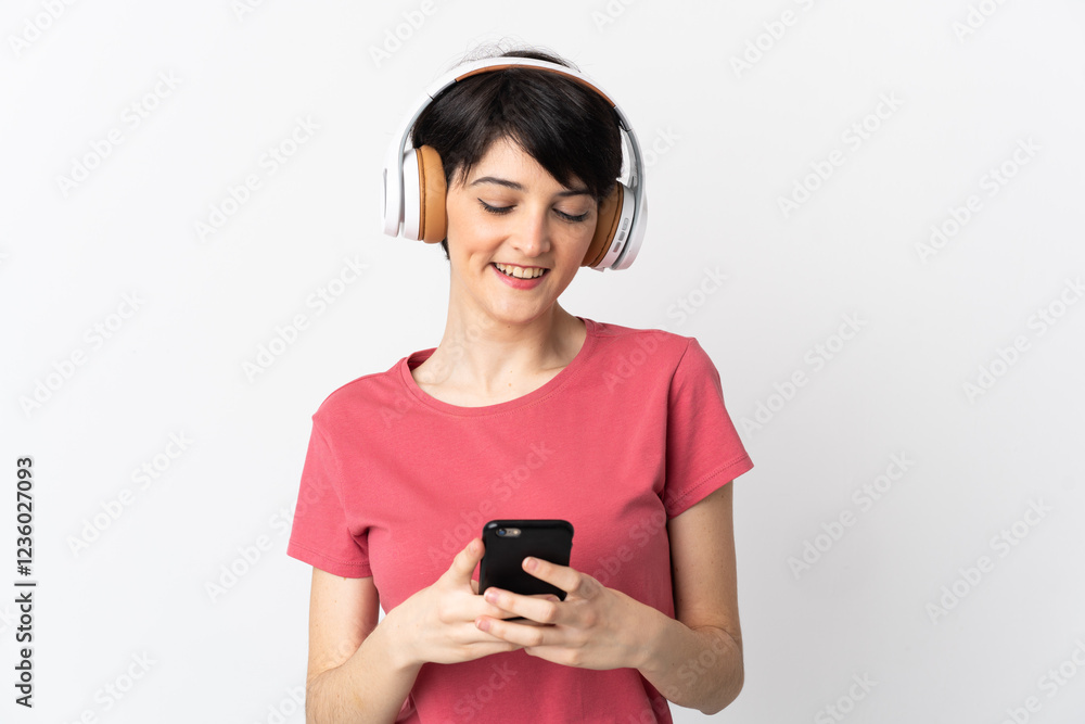 Woman with short hair isolated on white background listening music and looking to mobile Woman with short hair isolated on white background listening music and looking to mobile