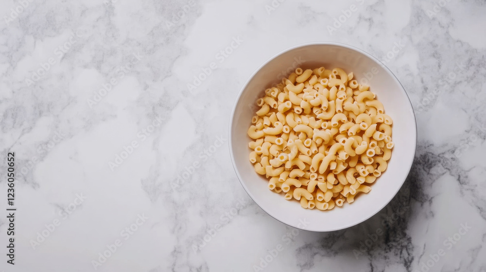 Pasta in a white bowl on a marble countertop ready for cooking or serving at a casual meal Pasta in a white bowl on a marble countertop ready for cooking or serving at a casual meal