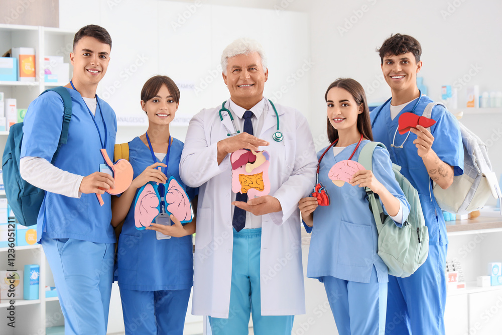 Mature doctor and medical students with paper organs at university Mature doctor and medical students with paper organs at university