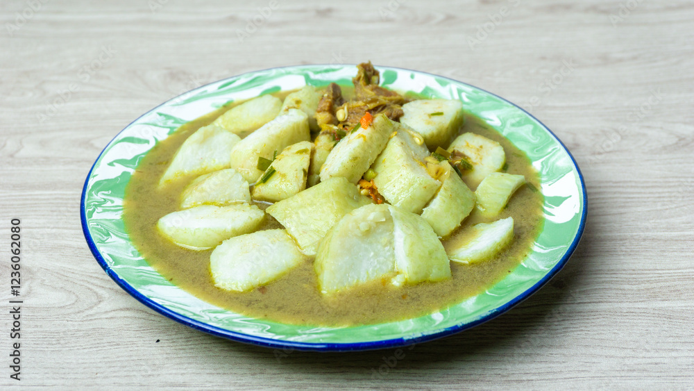 Soto daging (Indonesian meat soup) with lontong (rice cake) in indoneisan plate Soto daging (Indonesian meat soup) with lontong (rice cake) in indoneisan plate
