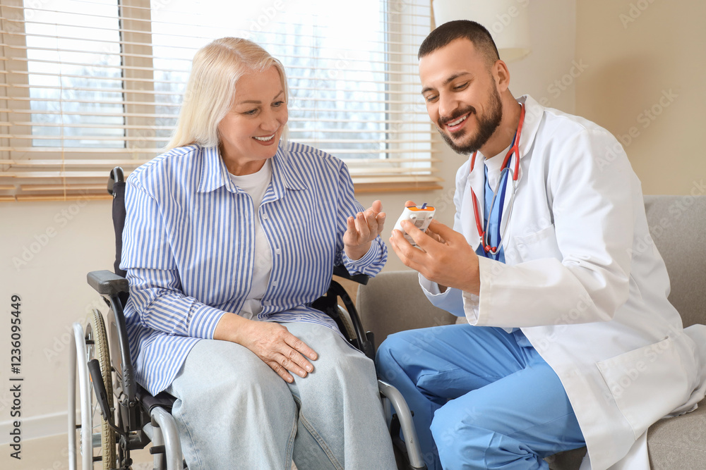 Male doctor with mature woman in wheelchair using glucometer at home Male doctor with mature woman in wheelchair using glucometer at home