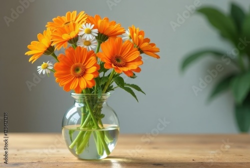 Wallpaper Mural A cheerful bouquet of orange and white daisies arranged in a clear glass vase, resting on a rustic wooden surface Torontodigital.ca