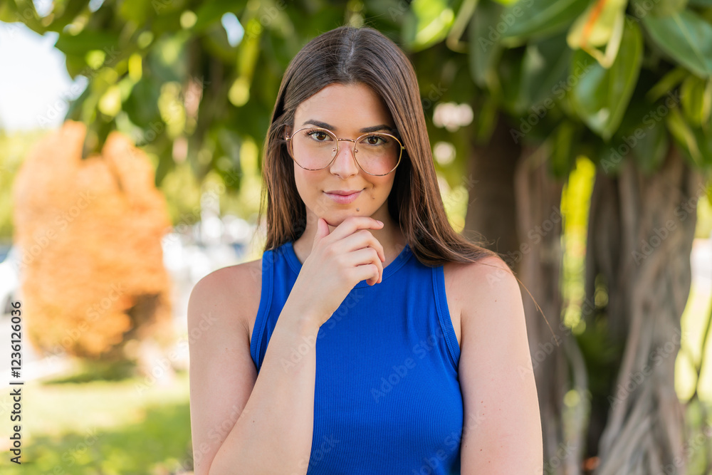 Φωτογραφία Young pretty Brazilian woman with glasses at outdoors thinking