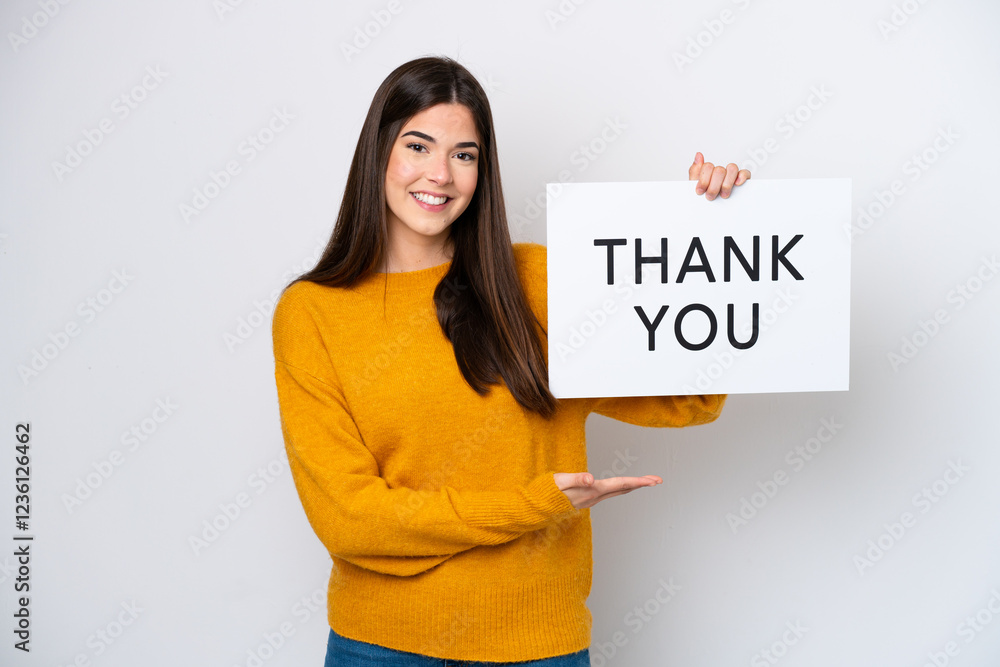 Young Brazilian woman isolated on white background holding a placard with text THANK YOU and pointing it Young Brazilian woman isolated on white background holding a placard with text THANK YOU and pointing it