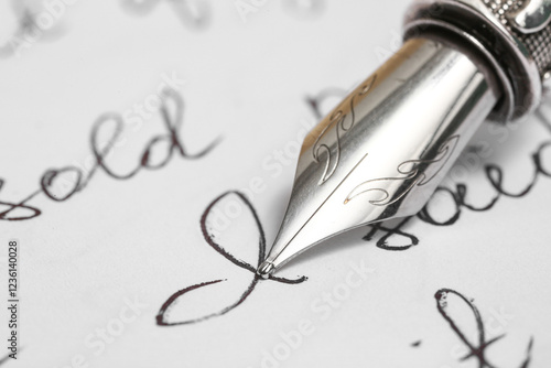 Paper sheet with letters and nib pen, closeup photo