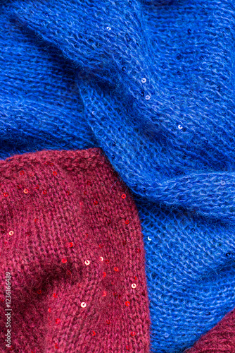 Obraz na płótnie Red and blue knitted sweater with sequins. Sequinned knitwear. Sequin pattern in needlework. Knitting hobby. Knitter work. Sequins texture in knitwear. Bright knitted fashion for holidays. w salonie