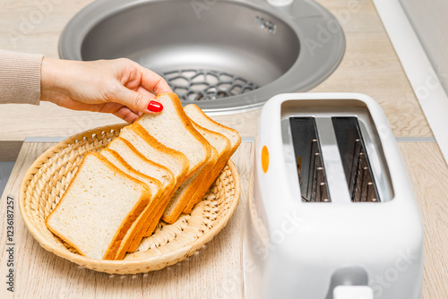 housewife frying bread in a toaster, in the kitchen. woman making toast. bread for toast. piece of fried bread.  photo